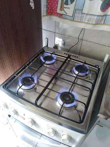 Fogão inox de 4 bocas com chamas azuis reguladas depois da manutenção em Porto Alegre