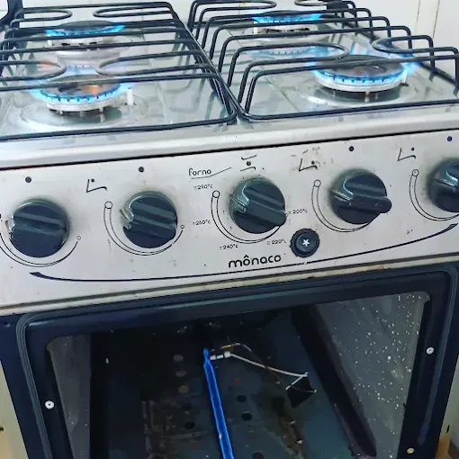 Fogão Mônaco com forno aberto mostrando o queimador do forno aceso após troca de peça